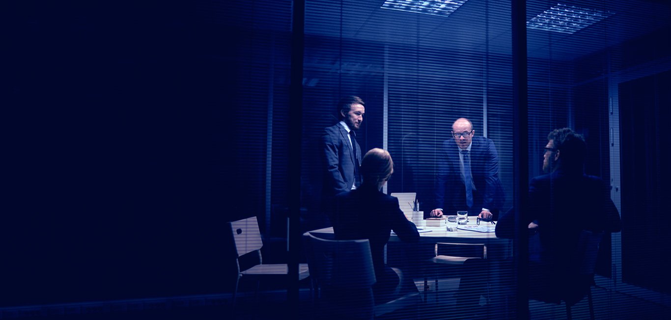 A group of professionals in a tense meeting setting, representing challenging workplace dynamics.