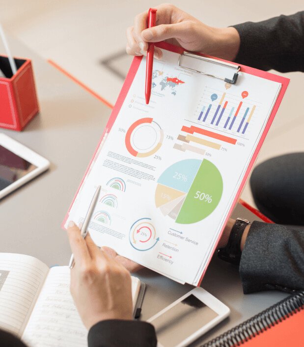 Professionals reviewing charts and metrics on a clipboard, representing data-informed organizational planning.