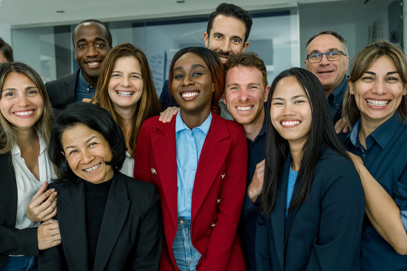 A diverse group of professionals standing together and smiling, representing belonging, connection, and shared success at work.