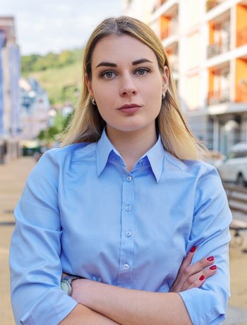 A professional woman standing with a focused expression, representing presence and authenticity in the workplace.