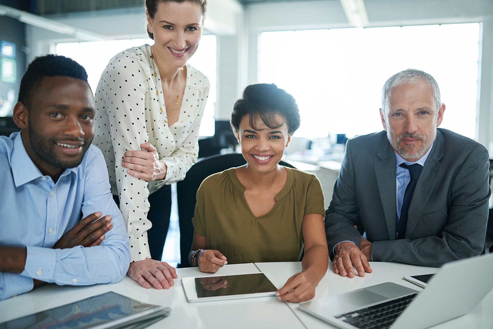 A diverse group of professionals gathered around a table, collaborating and focused on shared work.