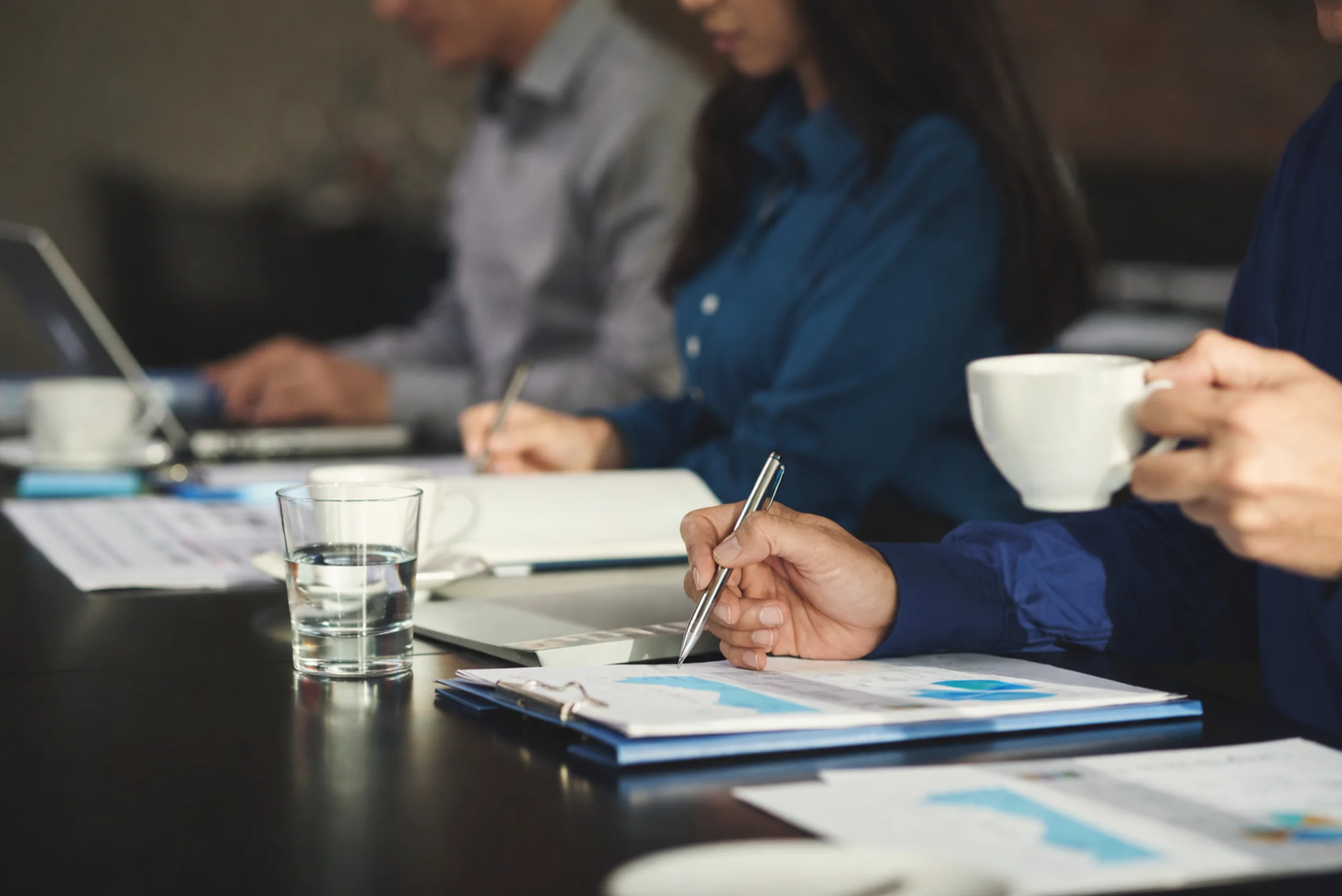 Professionals reviewing documents and charts during a focused working session, representing assessment and analysis.