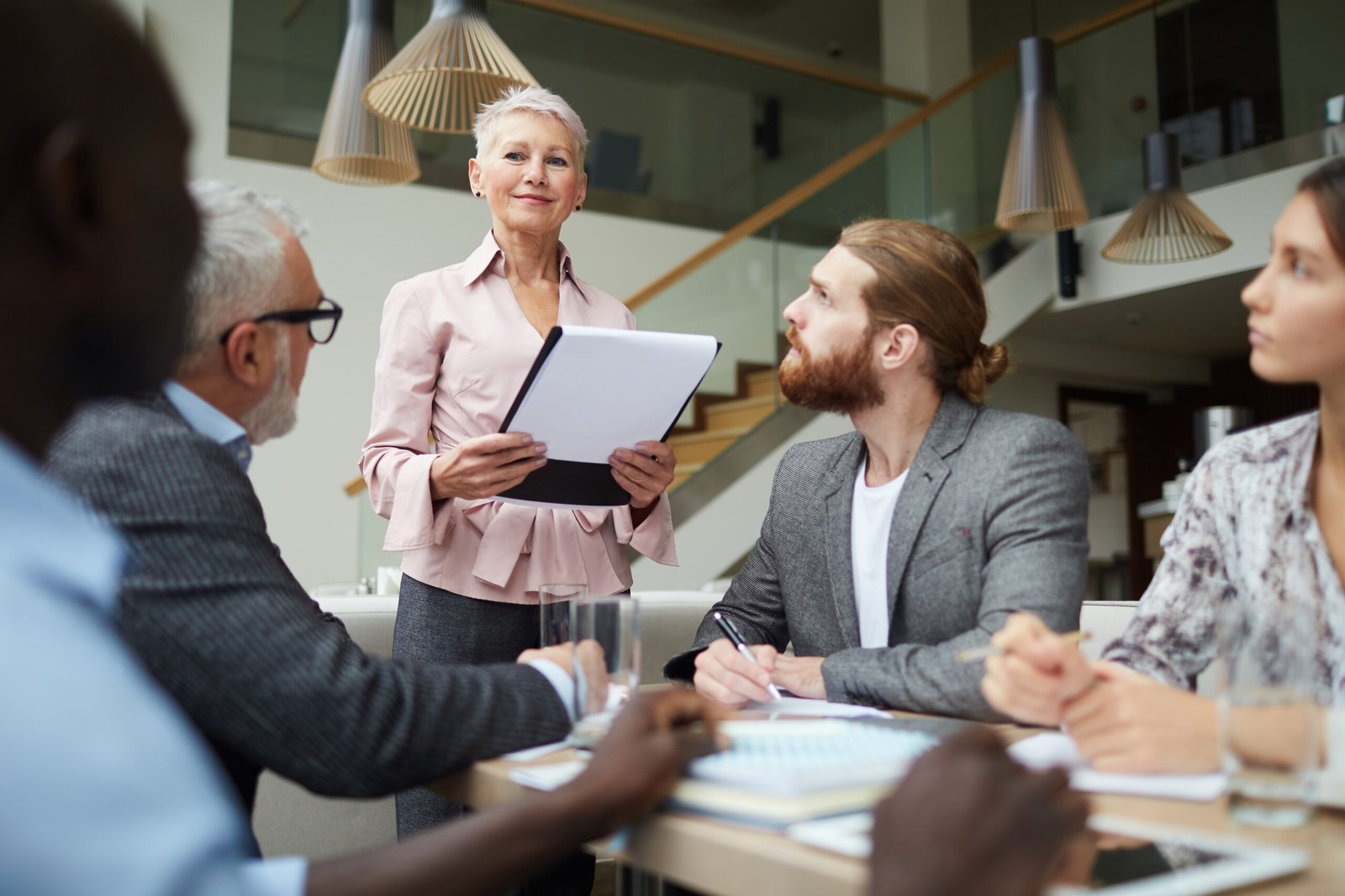 Senior business leader presenting to a team during a workplace meeting.