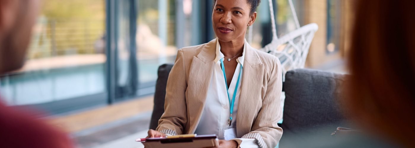 African American real estate agent talking with her clients during a meeting.