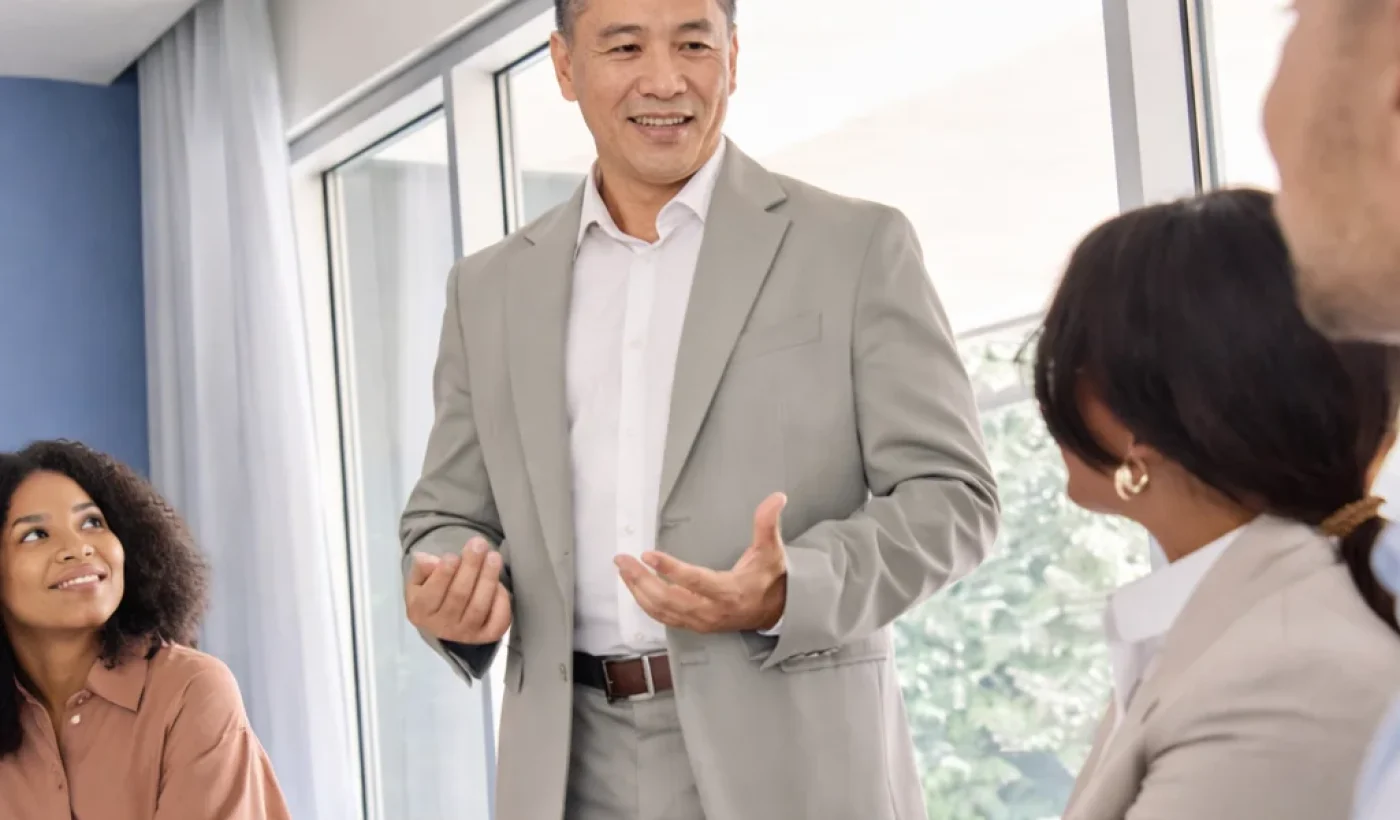 A leader speaking with colleagues during a discussion, representing executive coaching and leadership development.